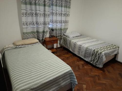 2 camas en una habitación con cortinas en Lo de Marta en Salta