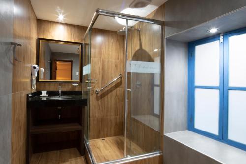 a bathroom with a glass shower and a sink at Hotel Rojas Inn in Cusco
