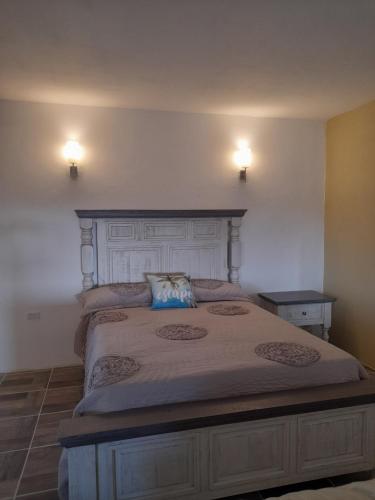 a bed in a bedroom with two lights on the wall at BAJA SUITES UPSTAIRS in Punta Abreojos