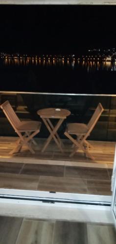 a view of two chairs and a table in a window at Apartments with sea view in Prcanj in Kotor