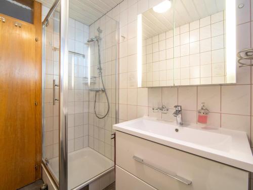 ein Badezimmer mit einem Waschbecken, einer Dusche und einer Badewanne in der Unterkunft Bitschnau in Vandans