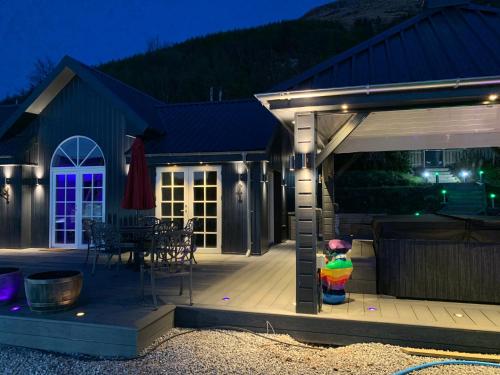 a covered deck with a fire hydrant in front of a house at Little Fox Lodge Luxury Hideaway with Hot Tub Glencoe Near Fortwilliam in Glencoe