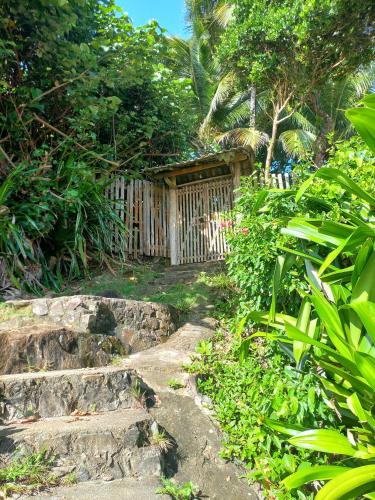 a garden with a wooden fence and some plants at Chalé na Praia da Tiririca in Itacaré