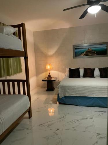 a bedroom with two beds and a ceiling fan at Cabañas Luxury con Lagoon Club - Adults Only in Bacalar
