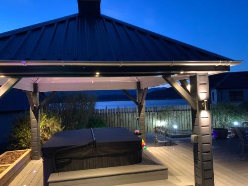 a gazebo with a black roof on a deck at Little Fox Lodge Luxury Hideaway with Hot Tub Glencoe Near Fortwilliam in Glencoe