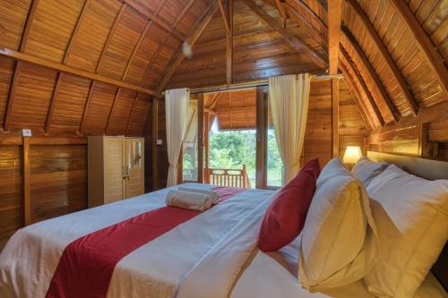 a bedroom with a large bed in a wooden house at Dekara Cottages in Nusa Penida