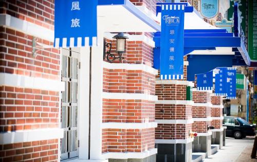 a brick building with blue and white signs on it at 翠安儂風旅 in Taitung City