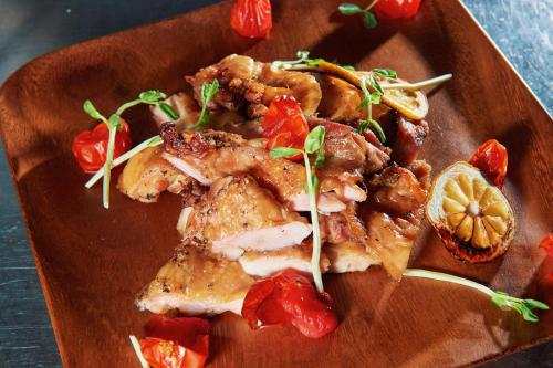 a plate of food with chicken and tomatoes on it at 翠安儂風旅 in Taitung City