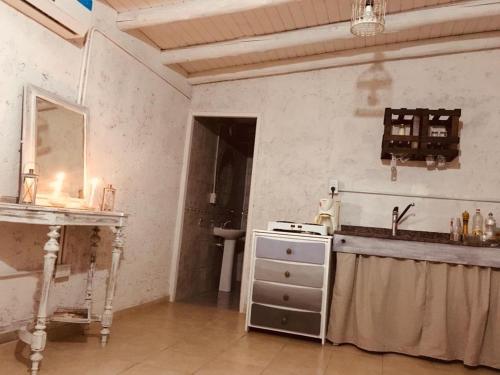 a kitchen with a stove and a sink in a room at Rincon La Magda in Ciudad Lujan de Cuyo