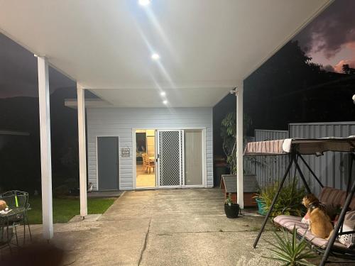 a porch of a house with a dog sitting on a swing at Urban Retreat in Wollongong