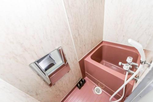 a bathroom with a red sink and a mirror at HIDEOUT in Sapporo