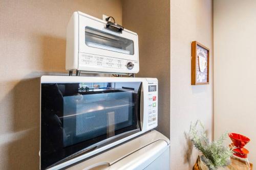 a microwave sitting on top of a refrigerator at GRAVITY in Sapporo