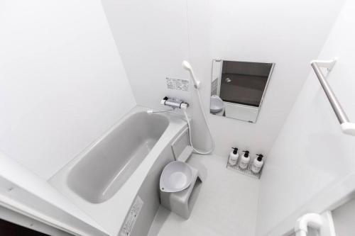 a white bathroom with a toilet and a sink at GRAVITY in Sapporo