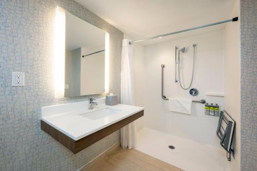 a white bathroom with a sink and a mirror at Holiday Inn Express Toronto Downtown by IHG in Toronto