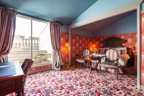 a bedroom with a bed and a table and chairs at InterContinental Bordeaux Le Grand Hotel by IHG in Bordeaux