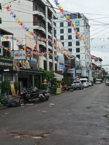 a city street with buildings and flags and motorcycles at Mekong Riverside in Vientiane