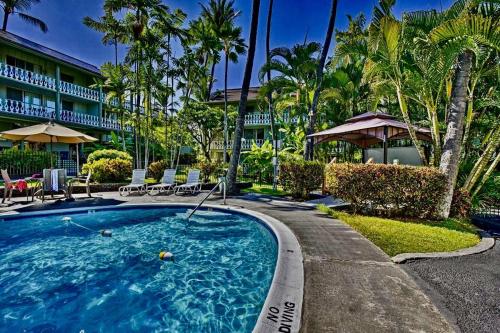 a swimming pool in front of a hotel with palm trees at GARDEN VIEW STUDIO - KONA ISLANDER INN CONDOS condo in Kailua-Kona