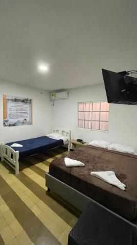 a room with two beds and a sign on the wall at Alojamiento Mamá Juana in Ríohacha