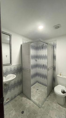 a bathroom with a shower and a toilet and a sink at Alojamiento Mamá Juana in Ríohacha