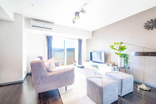 a living room with two chairs and a television at GIFT in Otaru