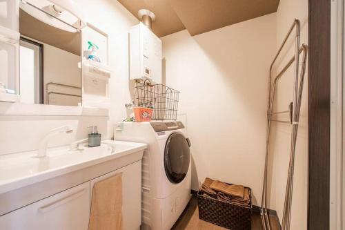 a laundry room with a washing machine and a sink at GLITZ in Otaru