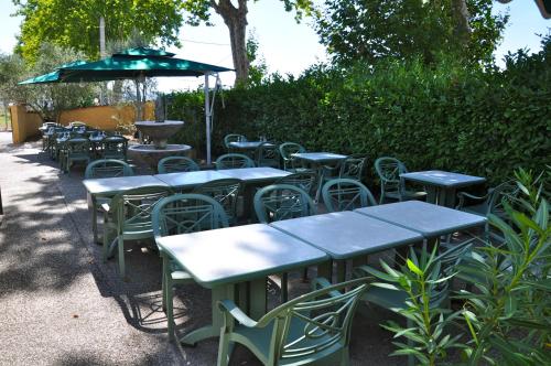 a group of tables and chairs with an umbrella at Le Provence in Manosque