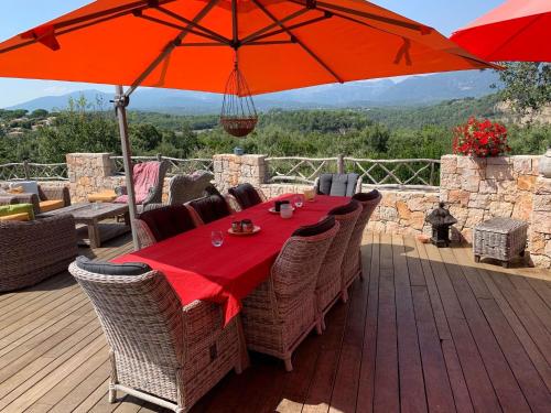 um deque de madeira com uma mesa e um guarda-chuva em Beautiful villa near Valbonne with garden em Villeneuve-Loubet