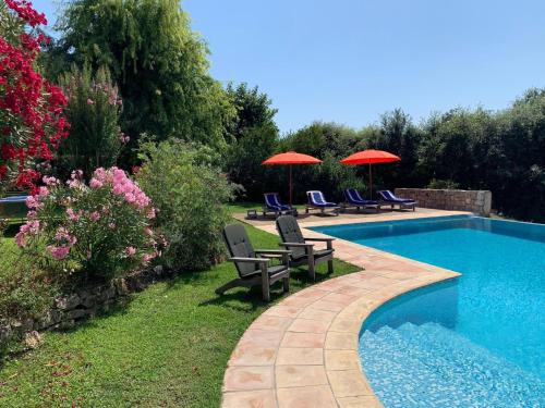 uma piscina com duas cadeiras e guarda-sóis ao lado em Beautiful villa near Valbonne with garden em Villeneuve-Loubet