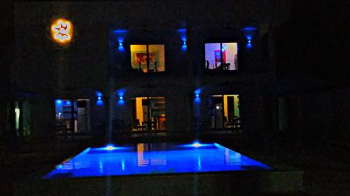 a building with blue lights in front of a building with a clock at Villa Star of the Sea in Barra de Navidad