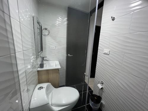 y baño con aseo blanco y lavamanos. en HABITACION AMOBLADA SECTOR LAURELES-ESTADIO #1 Madrid, en Medellín