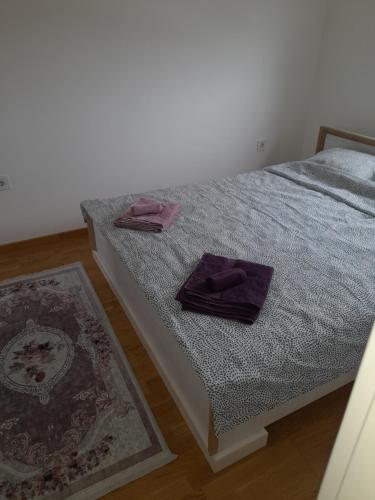 a bedroom with a bed with purple towels on it at Apartment Rustik in Novi Sad