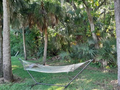 a hammock in a garden with palm trees at Travel Inn of Titusville in Titusville