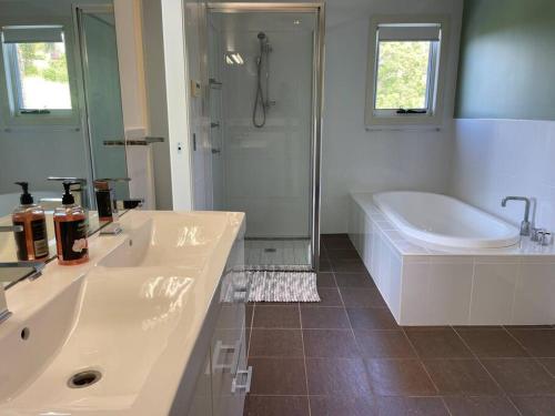 a bathroom with a tub and a sink and a shower at Ocean View Oasis, Coffs Harbour in Coffs Harbour