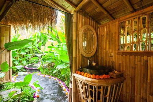 a bathroom with a sink in a room with a garden at Balikayanas Bamboo House - Miggiell House in Karangasem