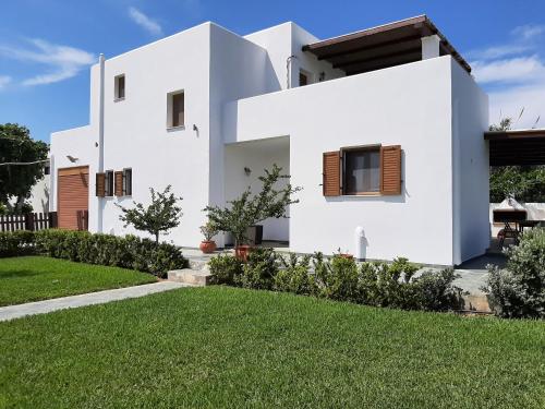 a white house with a green yard at Luxury 3BR Sunrise Villa , Seaside Gyrismata in Skiros