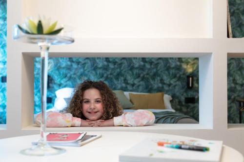 a young girl laying on a table in front of a mirror at Sant'Ambrogio Apartments, Reception h24 in Milan