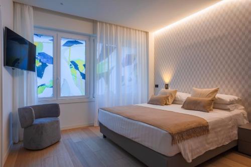 sypialnia z łóżkiem, oknem i krzesłem w obiekcie Sant'Ambrogio Apartments, Reception h24 w Mediolanie