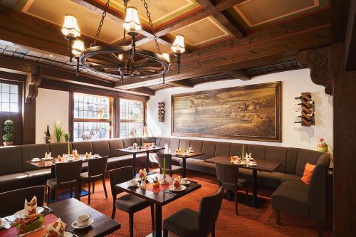 a restaurant with tables and couches and a painting at Altdeutsche Weinstube - Superior in Rüdesheim am Rhein