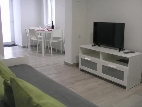a living room with a flat screen tv on a white cabinet at Sea U in Chania Town