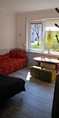 a living room with a red couch and a window at KAMBARIŲ nuoma Kaune - in Kaunas