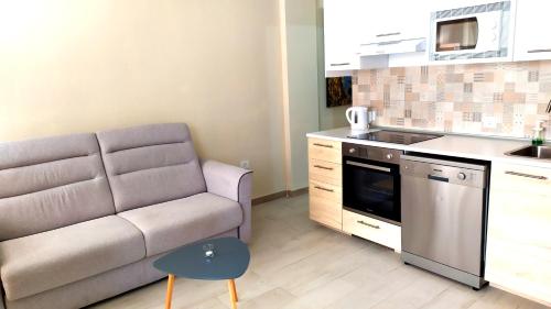 een woonkamer met een bank en een keuken bij Holiday rent Fuerteventura in Costa de Antigua