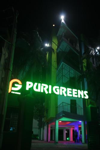 ein Neonschild vor einem Gebäude nachts in der Unterkunft HOTEL PURI GREENS in Puri