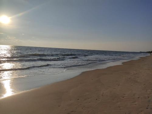 a beach with the sun rising over the ocean at Bachan's Casa in Cherai Beach