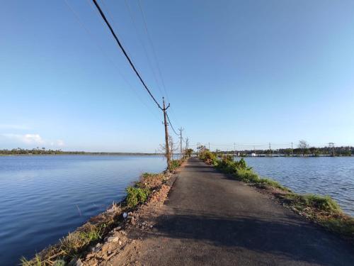 a dirt road next to a body of water at Bachan's Casa in Cherai Beach
