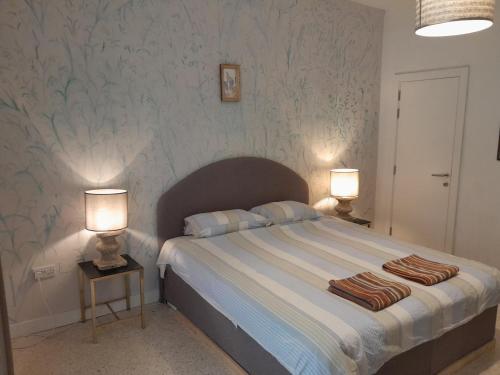 a bedroom with a large bed with two lamps at Lovely two bedroom apartment seconds from the Sea! in Sliema