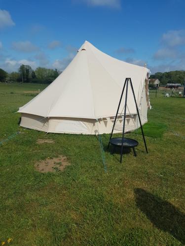 a white tent in a field with a swing at Two Jays Farm in Norwich