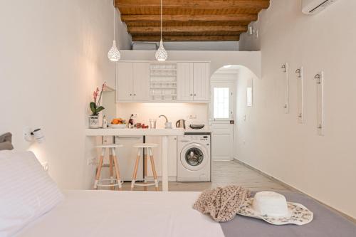 a white kitchen with a washing machine and a sink at Venetian Suites III in Naxos Chora