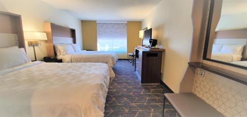 a hotel room with two beds and a mirror at Holiday Inn Staunton Conference Center by IHG in Staunton