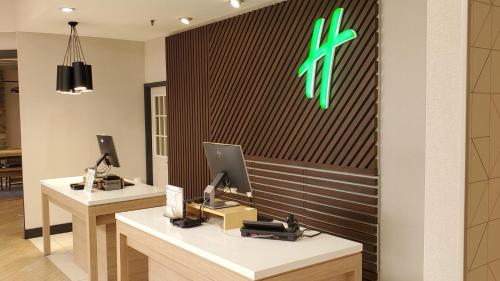 a lobby with two desks with computers on a wall at Holiday Inn Staunton Conference Center by IHG in Staunton
