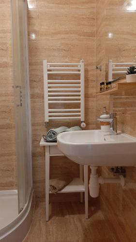 La salle de bains est pourvue d'un lavabo blanc et d'une baignoire. dans l'établissement Mewa, à Sztutowo